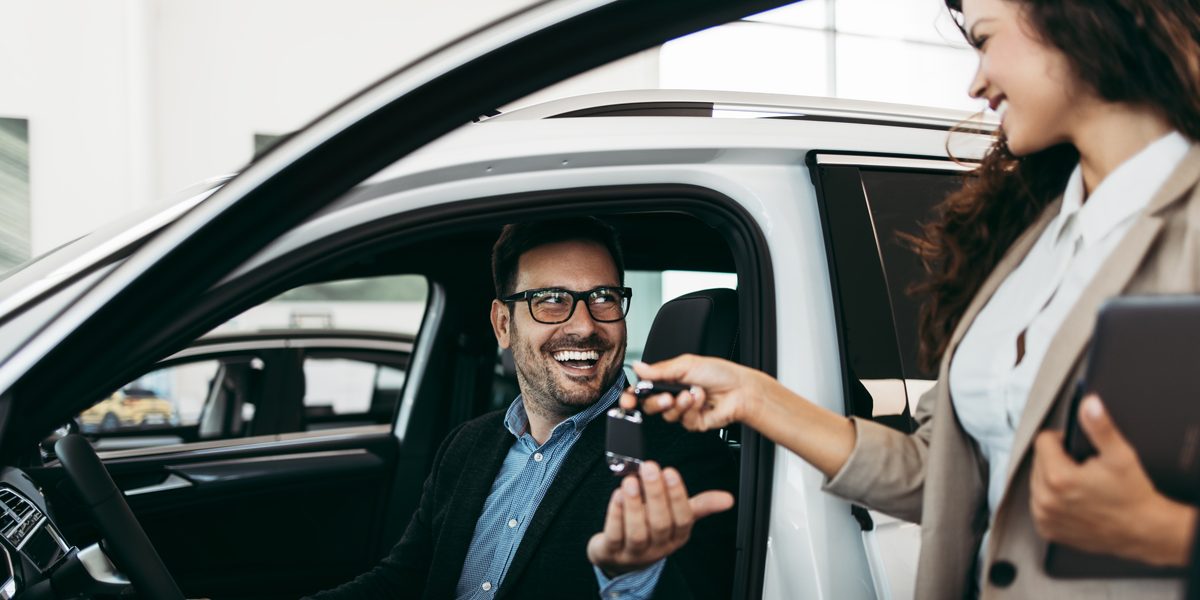 Man in rental car takes keys from an agent
